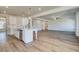 Open-concept kitchen flows into the spacious living area featuring hardwood floors, white cabinets and large island at 2781 Dolce Rd, Dacula, GA 30019