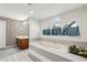 Bright bathroom featuring a large soaking tub with garden view and patterned wallpaper at 321 Covered Bridge Sw Pl, Smyrna, GA 30082
