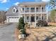 Charming two story home featuring a double porch, manicured landscaping, and attached two car garage at 8470 Wallace Tatum Rd, Cumming, GA 30028
