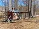 A quaint chicken coop is nestled amidst a beautiful grove of trees at 8470 Wallace Tatum Rd, Cumming, GA 30028