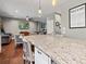Bright kitchen featuring granite counters, island, and view into the living room at 8470 Wallace Tatum Rd, Cumming, GA 30028