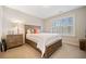 Cozy bedroom with wooden accents, bedside table, and natural light from the window at 300 South Village Sq, Canton, GA 30115