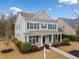 Two-story home featuring blue shutters, covered front porch with seating, and a well-maintained yard at 300 South Village Sq, Canton, GA 30115