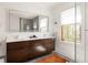 Bathroom featuring a glass enclosed shower, double sinks, dark wood cabinets, and natural light at 950 Clairemont Ave, Decatur, GA 30030