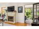 Cozy living space with a fireplace, TV and a view into a sunroom with lots of greenery at 950 Clairemont Ave, Decatur, GA 30030