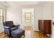 Bright sitting area featuring a cozy armchair, natural light, and dark hardwood flooring at 950 Clairemont Ave, Decatur, GA 30030