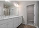 Bathroom featuring double sinks, white cabinets, and glass shower at 58 Black Gum Ln # 47, Auburn, GA 30011