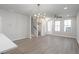 Spacious living area featuring plank floors, a modern light fixture, and lots of natural light at 58 Black Gum Ln # 47, Auburn, GA 30011