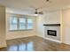 Light-filled living room with large windows, ceiling fan, and a modern fireplace with a wood mantle at 3321 Orwell Way # 3106, Cumming, GA 30041
