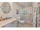 Bright bathroom with a granite vanity, circular mirror, and glass-enclosed shower at 3540 Tuxedo Nw Rd, Atlanta, GA 30305