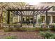 Exterior view of patio, stone planter boxes, outdoor dining area with pergola, and lush landscaping at 3540 Tuxedo Nw Rd, Atlanta, GA 30305