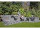 Outdoor kitchen with built-in grill, fireplace, and stone patio at 3540 Tuxedo Nw Rd, Atlanta, GA 30305