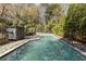 Inviting pool with stone surround, privacy fence, and mature trees at 3540 Tuxedo Nw Rd, Atlanta, GA 30305