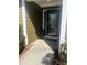 A welcoming front entrance with a glass paneled door, brick trim, and a manicured garden at 8236 Eastshore Dr, Union City, GA 30291