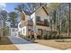 A modern home boasts a white exterior with warm wood accents, complemented by a spacious driveway at 1800 Charles Nw Pl, Atlanta, GA 30318