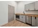 Cozy kitchenette featuring gray cabinets, butcher block countertops, and stainless steel appliances near a door at 1800 Charles Nw Pl, Atlanta, GA 30318