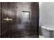 Contemporary shower featuring dark, vertically stacked tile, gold hardware, and a built-in niche at 1800 Charles Nw Pl, Atlanta, GA 30318