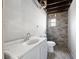 Unfinished basement bathroom featuring a white vanity, toilet, and modern wall tiling, ready for your personal touches at 3042 Peek Nw Rd, Atlanta, GA 30318