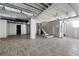 Open basement layout with wood-look flooring, exposed ceiling, and staircase, offering ample space for a customized living area at 3042 Peek Nw Rd, Atlanta, GA 30318