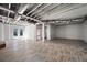 Bright, unfinished basement with wood-look flooring, glass door, and exposed beams, offering great potential for customization at 3042 Peek Nw Rd, Atlanta, GA 30318