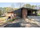 Brick home featuring an attached open garage or carport and outdoor deck area ready for renovation at 3042 Peek Nw Rd, Atlanta, GA 30318