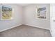 Bright bedroom featuring two windows with outside views and neutral walls and gray carpet at 4062 Doster Sw Dr, Atlanta, GA 30331