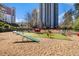 Large dog park featuring play structures and ample space for dogs to play, set against a skyline backdrop at 795 Hammond 1013 Dr, Sandy Springs, GA 30328