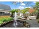 Tranquil backyard with a serene pond and fountain, complemented by a patio and landscaped grounds at 417 Lynne Cir, Alpharetta, GA 30009