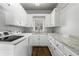 Well-lit laundry room with white cabinets, modern washer, dryer and granite countertops at 417 Lynne Cir, Alpharetta, GA 30009