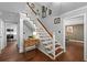 Elegant entryway with hardwood floors, staircase, and decorative accents leading to kitchen and dining area at 608 Apache Trl, Woodstock, GA 30189