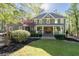 Charming two-story home featuring a welcoming front porch with wood columns and neatly landscaped yard with mature trees at 608 Apache Trl, Woodstock, GA 30189