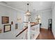 Upstairs hallway with wood floors and a decorative light fixture at 608 Apache Trl, Woodstock, GA 30189