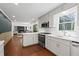 Open-concept kitchen with white cabinetry and stainless appliances overlooks the living area at 608 Apache Trl, Woodstock, GA 30189
