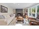 Cozy living room with fireplace, built-in shelves, and large windows overlooking wooded area at 608 Apache Trl, Woodstock, GA 30189