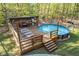 Outdoor pool surrounded by lush greenery, complete with an outdoor kitchen and lounge area at 608 Apache Trl, Woodstock, GA 30189