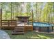 Pool with wooden deck and entertainment area nestled in a wooded setting at 608 Apache Trl, Woodstock, GA 30189