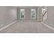 A spacious, carpeted living room with large windows offering natural light and a view of the outdoors at 1805 Hunters Moon Dr, Alpharetta, GA 30005
