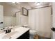 Bathroom featuring a dark vanity, a mirror, a shower with a white curtain, and paneling at 3874 Carriage Sw Ln, Conyers, GA 30094