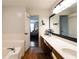 Bathroom with double vanity, separate tub and shower, and access to the main bedroom at 3874 Carriage Sw Ln, Conyers, GA 30094