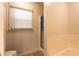 Cozy bathroom featuring a tiled shower, bathtub, and window with blinds at 3874 Carriage Sw Ln, Conyers, GA 30094