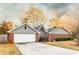 View of the garage and driveway of a cozy home featuring brick and gray siding at 3874 Carriage Sw Ln, Conyers, GA 30094