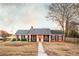 Charming brick home featuring a red front door, black shutters and inviting front porch at 3874 Carriage Sw Ln, Conyers, GA 30094