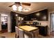 Well-lit kitchen boasts stainless steel appliances, black cabinetry, and butcher block island with seating at 3874 Carriage Sw Ln, Conyers, GA 30094