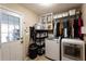 Functional laundry room equipped with modern appliances, storage shelves, and convenient access to the outdoors at 3874 Carriage Sw Ln, Conyers, GA 30094