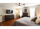 Comfortable main bedroom features a ceiling fan, hardwood floors, and a wall-mounted TV at 3874 Carriage Sw Ln, Conyers, GA 30094