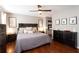Bedroom featuring wood floors, neutral walls, a ceiling fan, decorative wall art, and a closet at 3874 Carriage Sw Ln, Conyers, GA 30094