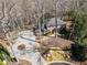 Stunning aerial view of a brick home with a circular driveway surrounded by lush landscaping and mature trees at 812 Burning Tree Se Ct, Marietta, GA 30067