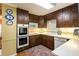 Cozy kitchen features ample dark wood cabinetry, built-in appliances, and a colorful accent rug at 812 Burning Tree Se Ct, Marietta, GA 30067