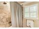 Updated shower featuring patterned tile, a shower curtain, and natural light at 812 Burning Tree Se Ct, Marietta, GA 30067