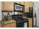 Galley kitchen featuring granite countertops, stainless steel appliances, and light wood cabinetry at 799 Hammond Dr # 205, Sandy Springs, GA 30328